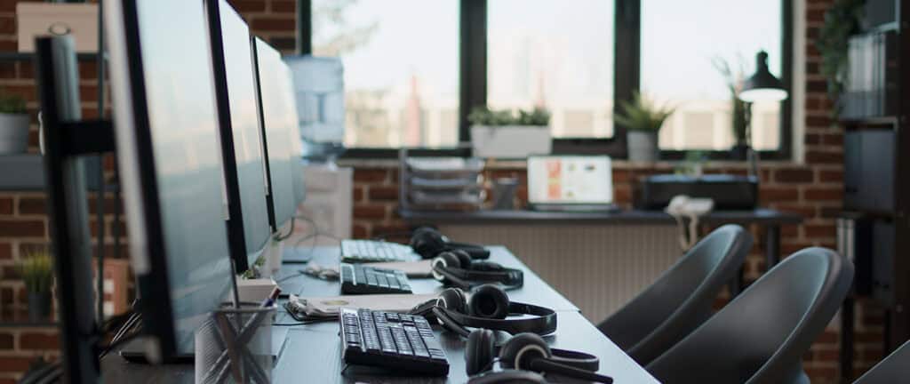 No people at desk with multiple computers in call center office