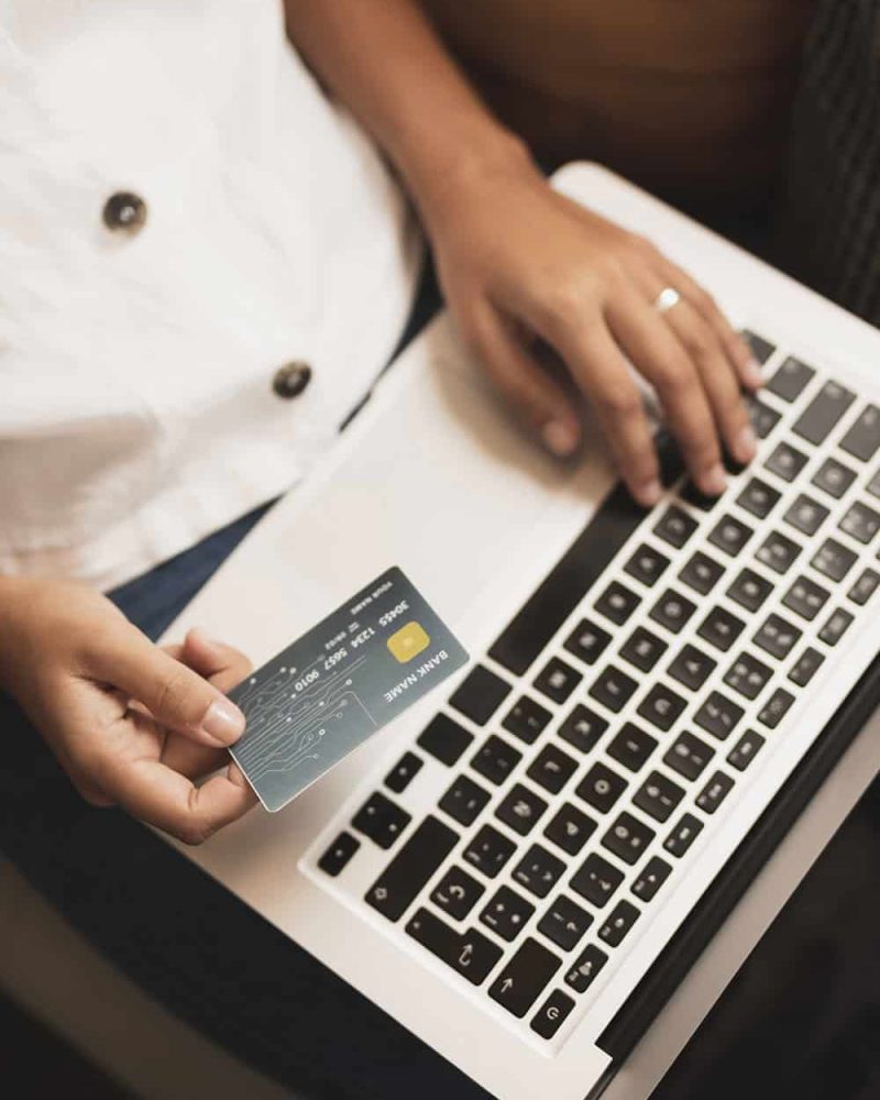 top-view-hands-holding-credit-card-laptop